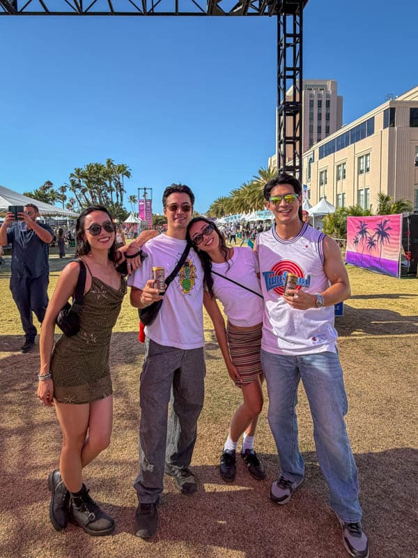 Four friends holding Spark Plug canned espresso martinis at Horizon Fest, San Diego